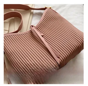Close-up of pink pleated PU leather handbag showing detailed vertical texture and gold hardware