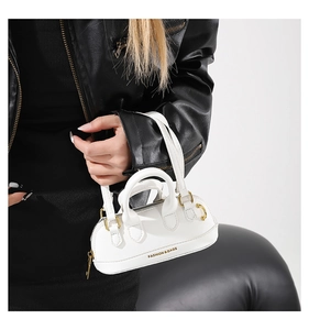 Close-up of a white leather mini handbag with FASHION & BAGS text and gold hardware detail