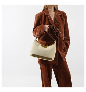 Detail of a nylon crescent crossbody bag with brown leather trim and woven strap on model