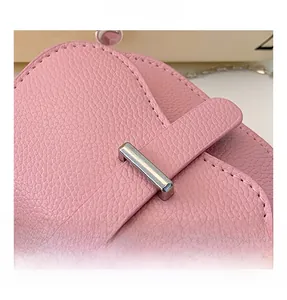 Détail d'un sac à main en cuir rose avec fermoir rectangulaire en métal argenté poli