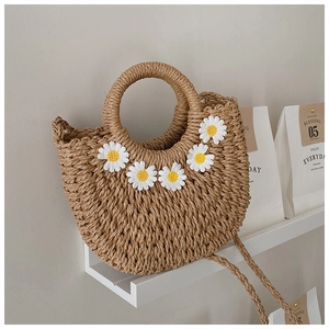 Chic woven straw crescent handbag with white daisy floral accents and shoulder strap