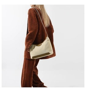 Detail of beige and olive green nylon canvas handbag paired with a brown corduroy suit