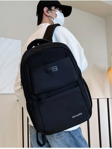 Detail view of the side mesh pocket and smooth zipper on this black nylon backpack