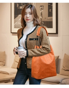 Détail du sac cabas orange avec motifs de crânes en relief et poignées en chaîne