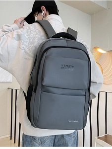 Detail of grey nylon backpack with multi-zipper pockets and breathable shoulder straps