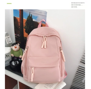 Detailed macro view of pink nylon backpack featuring durable pockets and woven rope zippers