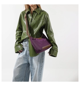 Detail of purple nylon crossbody bag with brown leather trim and adjustable shoulder strap