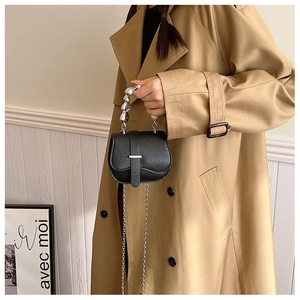 Détail du sac à main noir en cuir grainé avec une poignée sphérique en métal argenté