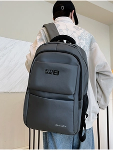 Detail of dark grey nylon backpack with front zipper pockets and waterproof texture