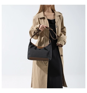 Fashionable dark grey nylon handbag with brown leather trim shown on an elegant model