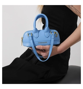 Detail of a bright sky blue PU leather mini Boston bag with gold FASHION & BAGS lettering
