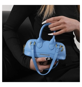 Detail of sky blue mini Boston bag with gold metal hardware and fashion text logo