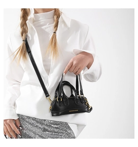 Close-up of black PU leather mini crossbody bag with gold Fashion & Bags lettering
