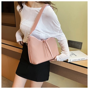 Detail of a pink pleated PU leather shoulder bag featuring a stylish textured finish