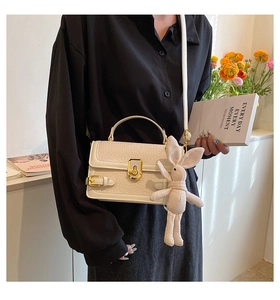 Détail du sac à bandoulière en cuir PU blanc crème avec fermoir doré et breloque lapin