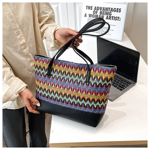 Detail of multi-color woven pattern on large tote bag with durable black leather base