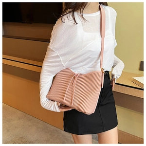 Detailed close-up of pink pleated PU leather shoulder bag with drawstring detail