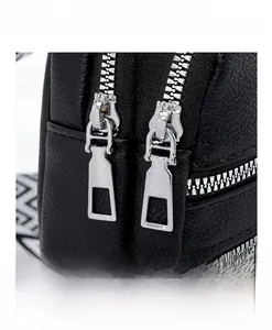 Macro shot of high-quality silver double metal zippers on black lychee grain leather bag
