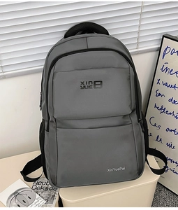 Detail of grey nylon backpack featuring ergonomic back system and reinforced top handle