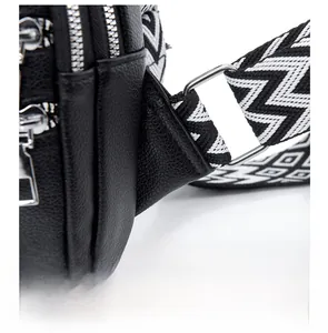 Close-up of reinforced shoulder strap stitching and silver metal buckle on black leather bag