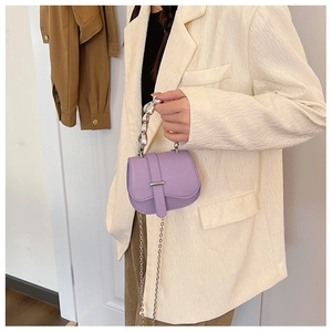 Gros plan du sac selle violet à motif litchi avec chaîne argentée et boucle en métal