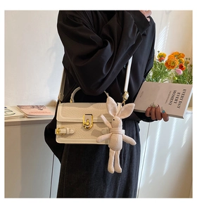 Sac bandoulière blanc texture litchi avec boucle dorée et breloque lapin rose