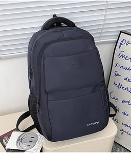 Detail view of durable nylon backpack showing multiple zipper compartments and side mesh pocket