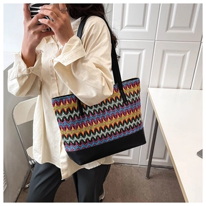 Detail of multi-color woven pattern shoulder bag with black faux leather base