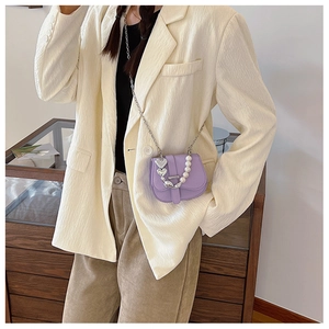 Détail du mini sac bandoulière lavande avec chaîne en perles et pendentif cœur argenté