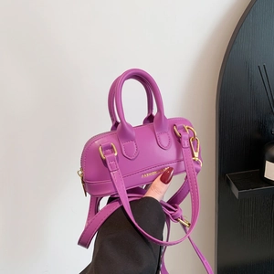 Fashionable magenta PU leather handbag for women with gold hardware and shoulder strap