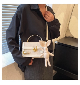 Détail du sac bandoulière blanc en PU avec boucle dorée et breloque lapin en peluche