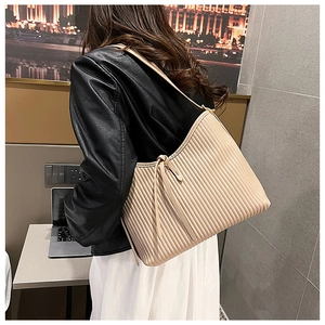 Detail of apricot hobo bag showing vertical pleated texture and soft PU leather material