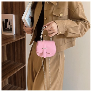 Vue détaillée du mini sac rose grainé avec poignée à perles argentées et bandoulière