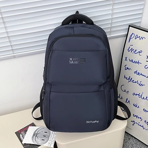 Navy blue nylon backpack with minimalist design featuring spacious pockets and comfortable straps