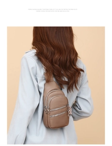 Detail view of brown PU leather crossbody bag with multiple zippers and wavy strap