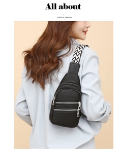 Detail of black pebbled leather crossbody bag with triple silver zippers and wide woven strap