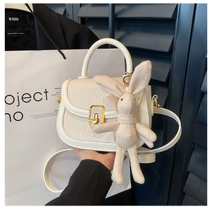 Chic cream mini square crossbody bag with crackle texture and cute rabbit charm