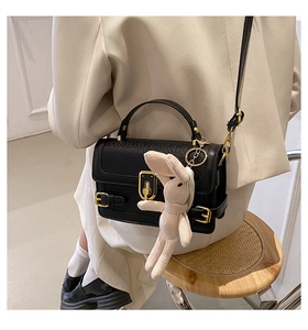 Détail du sac bandoulière noir effet croco avec fermoir doré et pendentif lapin