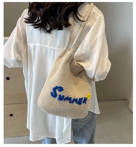 Détail de la broderie Summer et fleur jaune sur le sac à main tissé blanc cassé