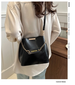 Détail du sac seau noir en PU avec chaîne dorée et étiquette de mode sur le côté