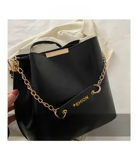 Détail du sac seau noir en cuir PU avec chaîne dorée et étiquette de mode