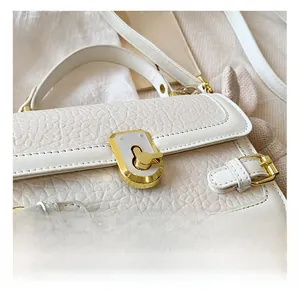 Gros plan détaillé sur le sac en cuir PU blanc grainé avec fermoir doré en métal