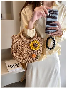 Detail of handmade straw shoulder bag with sunflower floral accent and drawstring lining