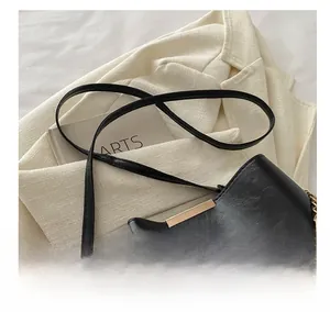 Détail d'un sac à main noir en similicuir avec barre dorée et sangle Fashion chic