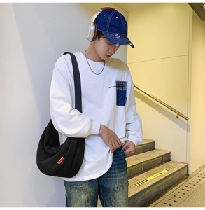 Detail of trendy nylon crossbody bag styled with casual street outfit on a model