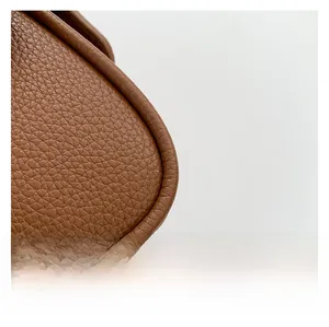 Close-up detail of premium brown lychee pattern leather texture on a trendy handbag