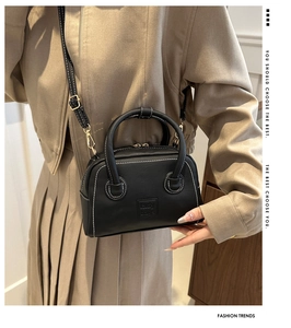 Detailed view of black PU handbag with white contrast stitching and lady bags embossed patch