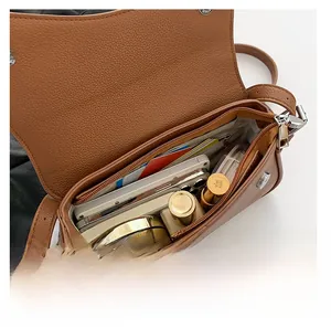 Macro view showing the brown leather bag interior storage capacity with zipper pocket