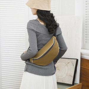 Fashionable mustard yellow crossbody bag worn by a model in a minimalist home interior