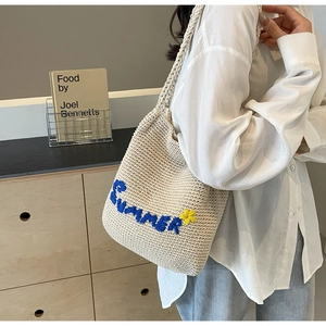 Détail du sac cabas tissé avec broderie Summer bleue et motif de fleur jaune